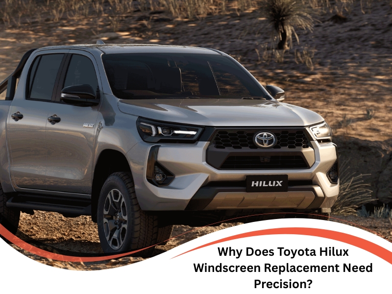Toyota Hilux windscreen replacement showing a modern silver Hilux parked on rugged terrain at sunset.